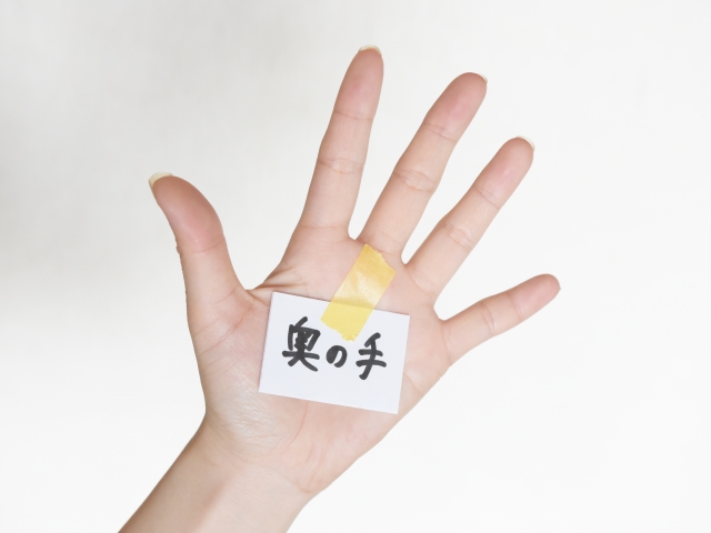 奥の手と書かれた紙を張り付けた手のひら