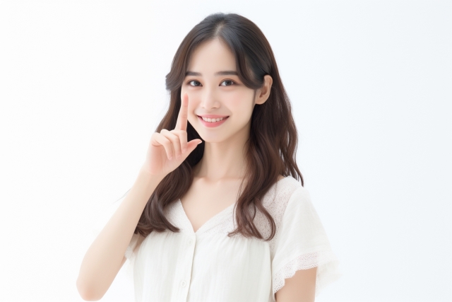 顔の前で指を立てている笑顔の女性