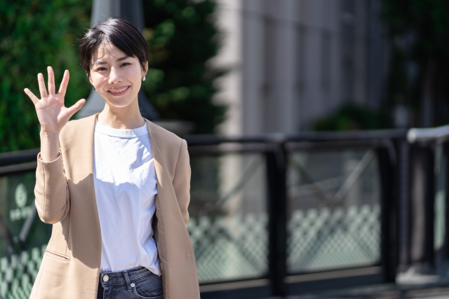 手で5のジェスチャーをする女性