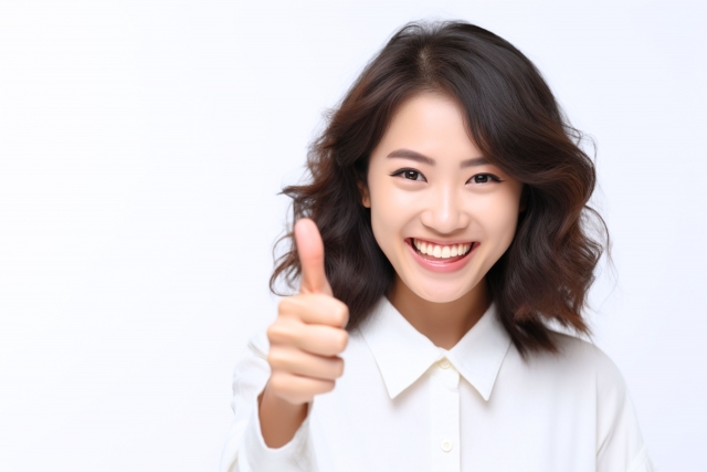 こちらを向いて親指を立てる笑顔の女性