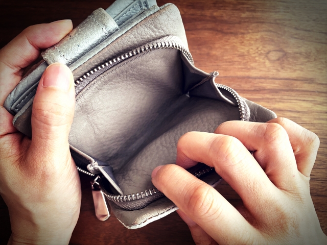 空っぽの財布をあける手元