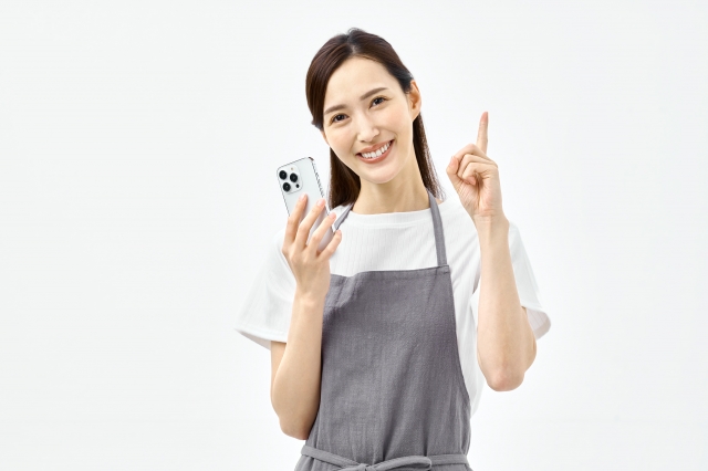 スマートフォンを持ち説明する主婦