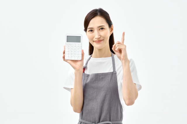 電卓を持ち指差しポーズする女性