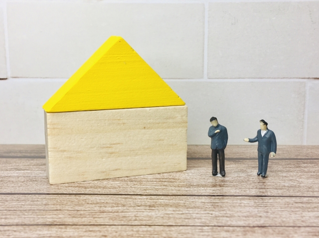 家の前で受け渡しをする2人